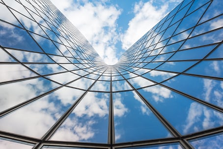 Blue sky, white clouds reflecting on window glass